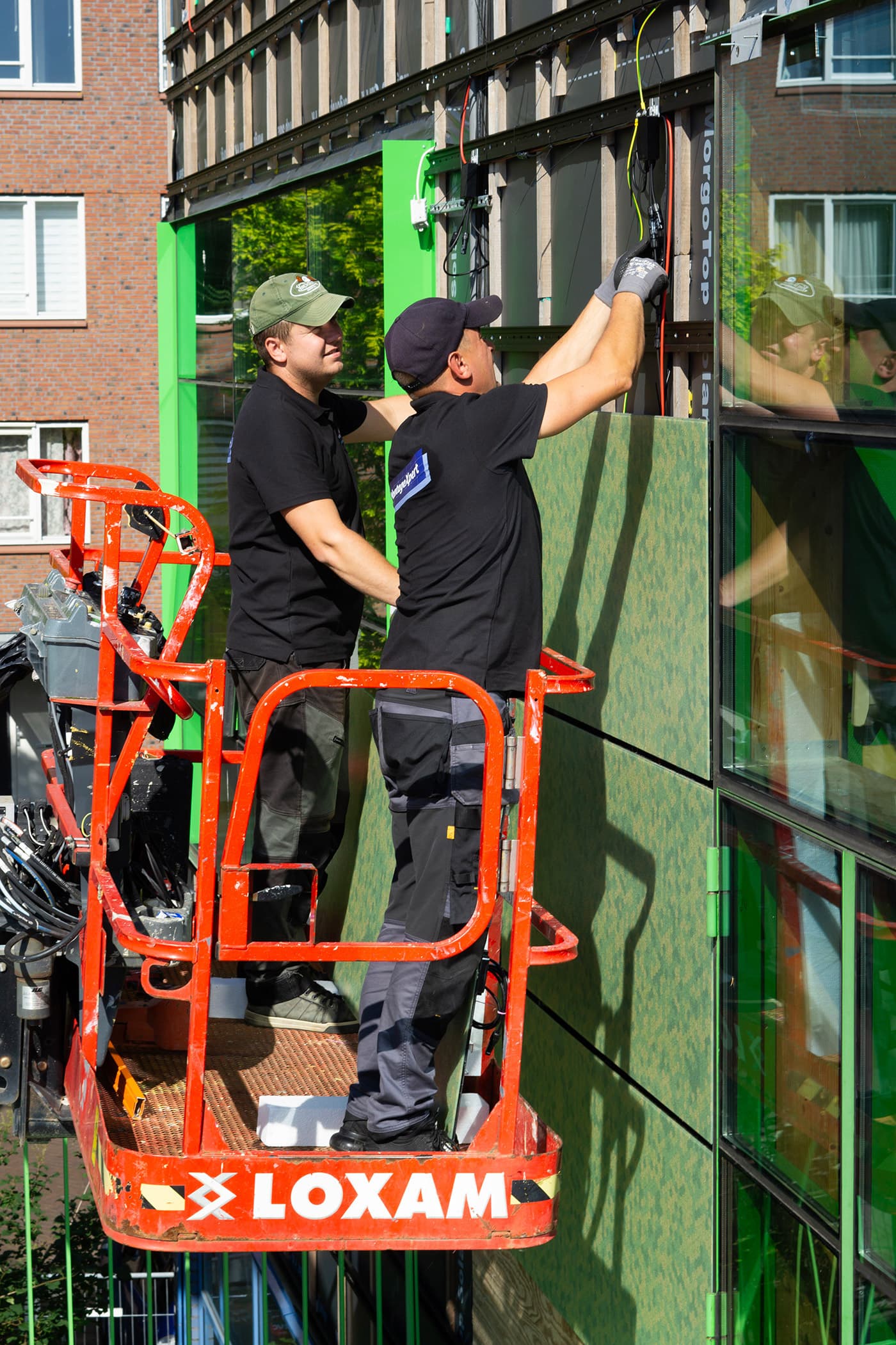 Installatie gekleurde zonnepanelen op de gevel basisschool De Kikker | Dok Architecten | Solarix